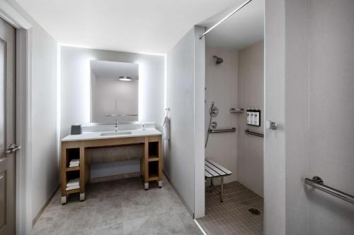 a bathroom with a sink and a mirror at Hyatt House Colorado Springs Airport in Colorado Springs