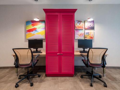 a red door in a room with two chairs at Home2 Suites By Hilton Santa Rosa Beach in Santa Rosa Beach