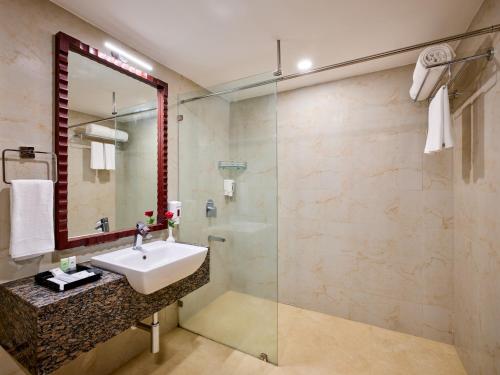 La salle de bains est pourvue d'un lavabo et d'une douche. dans l'établissement Daiwik Hotels Rameswaram, à Rameswaram