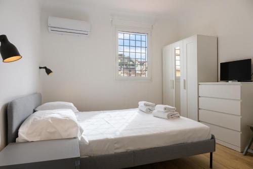 een witte slaapkamer met een bed en een televisie bij Sapiti Modern by Mmega in Florence