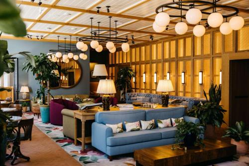 a lobby with blue couches and tables and lamps at The Drayton Hotel Savannah, Curio Collection by Hilton in Savannah