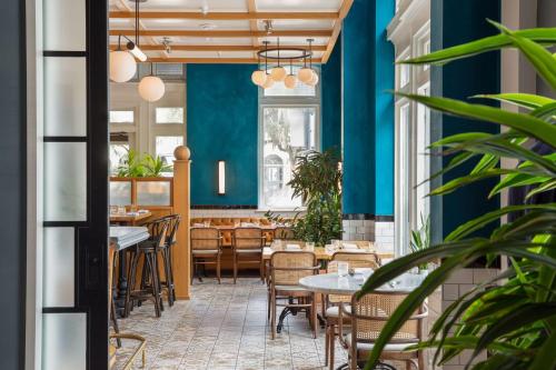 a restaurant with blue walls and tables and chairs at The Drayton Hotel Savannah, Curio Collection by Hilton in Savannah