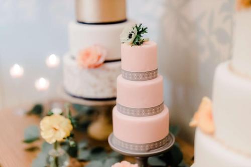 eine dreistufige rosa Hochzeitstorte mit Blumen drauf in der Unterkunft The Drayton Hotel Savannah, Curio Collection by Hilton in Savannah