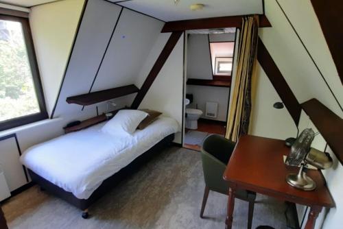 a small bedroom with a bed and a desk and a table at Hotel Kasteelhof 'T Hooghe in Ypres