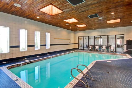 a swimming pool with chairs in a building at Radisson Hotel & Conference Centre West Edmonton in Edmonton