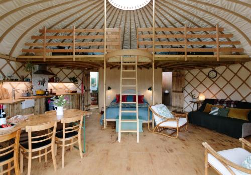 um quarto com uma cama alta numa tenda em Tree Field Yurt at Moor Farm em Godshill