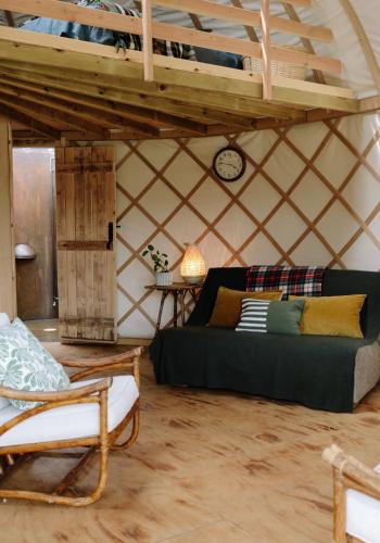 a room with a bed and a couch in a yurt at Tree Field Yurt at Moor Farm in Godshill