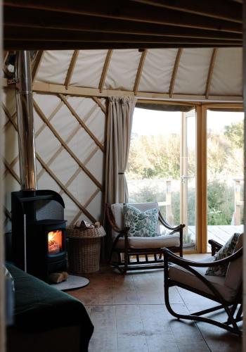 a living room with a fireplace in a yurt at Tree Field Yurt at Moor Farm in Godshill