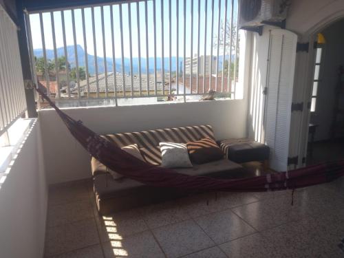 a hammock in a room with a large window at Pousada Litoral Norte Caragua in Caraguatatuba