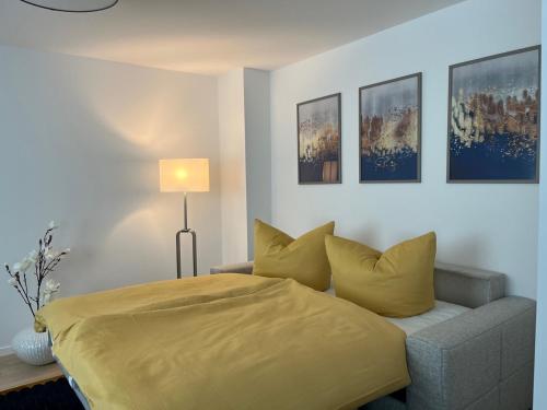 a bedroom with a yellow bed and a couch at Apartments Am Siebenborn in Eisenach