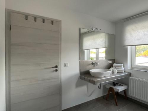 ein Bad mit einem Waschbecken und einem Spiegel in der Unterkunft Apartments Am Siebenborn in Eisenach