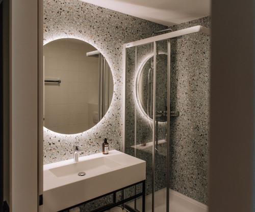 uma casa de banho com um lavatório e um espelho em HEINhotel vienna airport em Schwechat