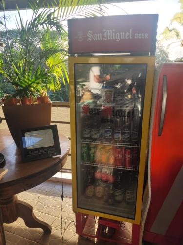 a refrigerator filled with lots of drinks next to a table at La Vida Hostel in Puerto Princesa City