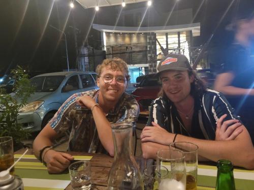 two men sitting at a table in a restaurant at La Vida Hostel in Puerto Princesa City