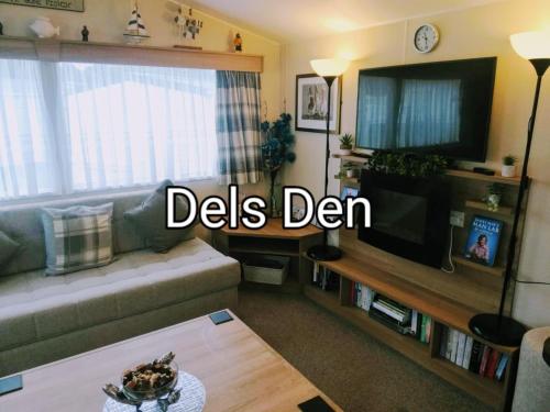 a living room with a couch and a flat screen tv at Del's den lakeside weeley bridge in Weeley