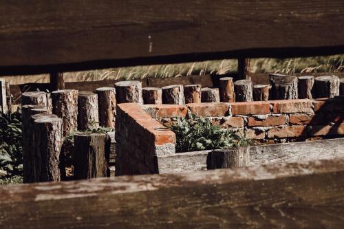 a brick retaining wall with a fence and a plant at Ecological farm Makrobios Panonija in Gornji Petrovci