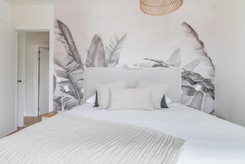 - une chambre dotée d'un lit blanc avec des plantes sur le mur dans l'établissement Home2Book Panoramic Views & Stylish Design Agaete, à Agaete
