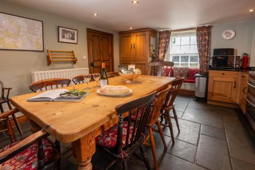 a kitchen and dining room with a wooden table and chairs at Wayside Cottage Clappersgate Ambleside in Ambleside