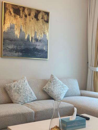 a living room with a couch and a painting at ROYAL APARTMENTS DUBAI in Dubai