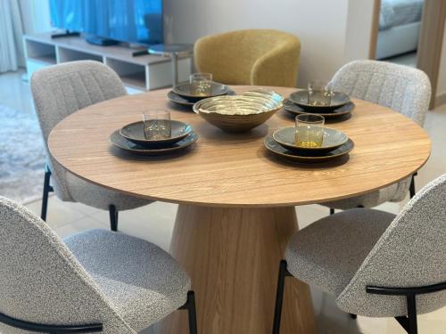 a wooden table with plates and bowls on it at ROYAL APARTMENTS DUBAI in Dubai
