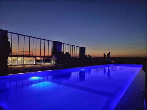 a swimming pool with blue lights in front of a building at Artsy Urban 1Br along Kiambu Road with a pool and scenic views in Kiambu