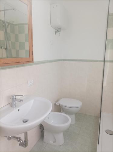 a bathroom with a sink and a toilet and a mirror at Affitta camere Via Piave in Foligno