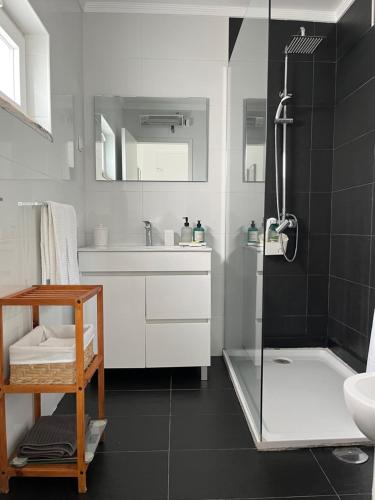 a white bathroom with a shower and a sink at Casa do Cedro no Campo in Correias