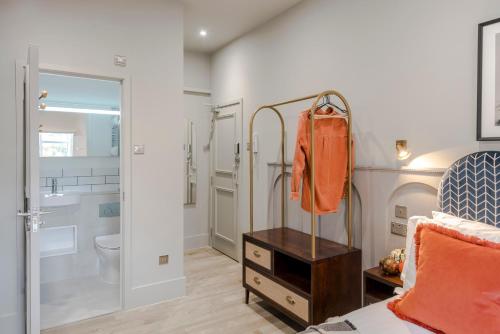 um quarto com uma cama e uma casa de banho com um chuveiro em Tooting - Your Apartment em Londres