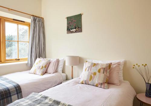 dos camas sentadas una al lado de la otra en un dormitorio en The Grainstore at Moor Farm, en Godshill