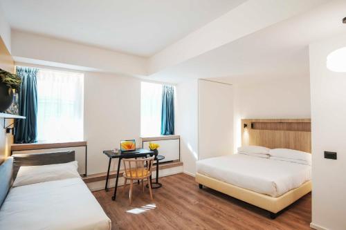 a hotel room with two beds and a table at Aparthotel Colombo Roma in Rome