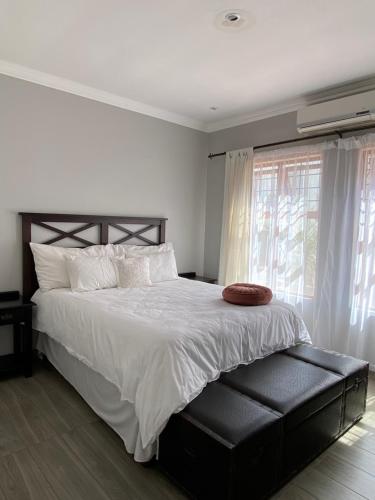 um quarto com uma cama grande e uma janela em Modern Serene 3 Bedroom Villa em Joanesburgo