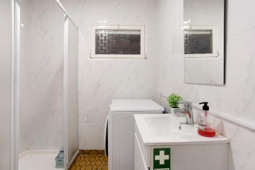 a white bathroom with a toilet and a sink at Casal Do Farrobo in Funchal