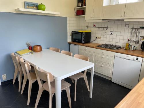 cocina con mesa blanca y sillas en Cosy 6P family home 'Notre Nid' close to the beach 300m Oostduinkerke - Belgian seaside, en Oostduinkerke-Bad