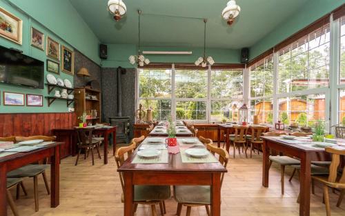 um restaurante com mesas e cadeiras de madeira e janelas em Hotel Na Skalkách em Nový Jičín