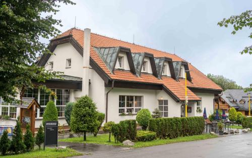 a house with a roof that has a sign on it at Hotel Na Skalkách in Nový Jičín