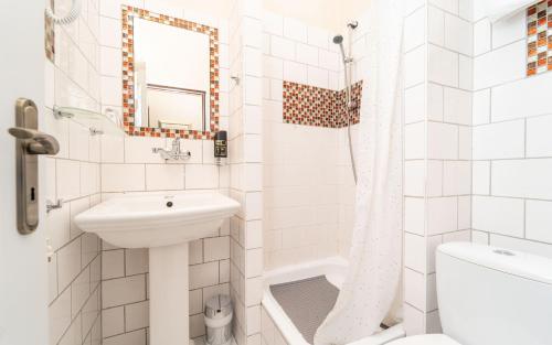 a white bathroom with a sink and a shower at Hotel Na Skalkách in Nový Jičín