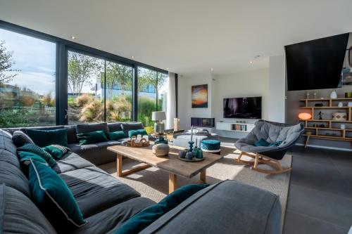 een woonkamer met een bank en een tafel bij Harbour Villas Zeeland in Arnemuiden