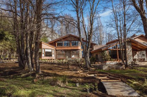 una casa en el bosque con árboles en PURA Hotel en Coyhaique