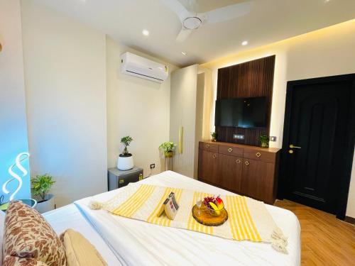a bedroom with a bed with a plate of fruit on it at Bedchambers, Saket in New Delhi
