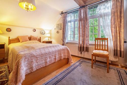 a bedroom with a bed and a chair and a window at Romatisches Ferienhaus in Gerdau