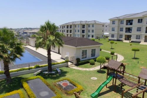 a backyard with a pool and a playground at Sunset View-Luxury Apartment in Sandton
