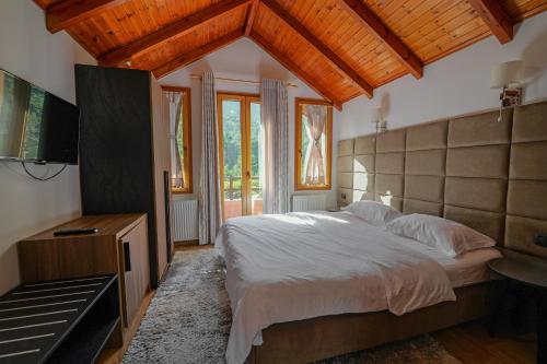 - une chambre avec un grand lit et une télévision dans l'établissement Hotel Sofo, à Llogara