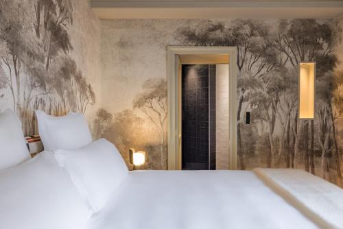 a bedroom with two beds and a wall mural at Le Pavillon de la Reine & Spa, Place des Vosges in Paris