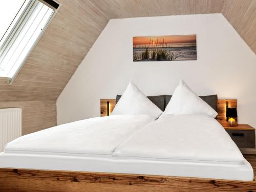 1 dormitorio con 1 cama grande con sábanas blancas en Dat Köhnsche Hus, en Kirchdorf