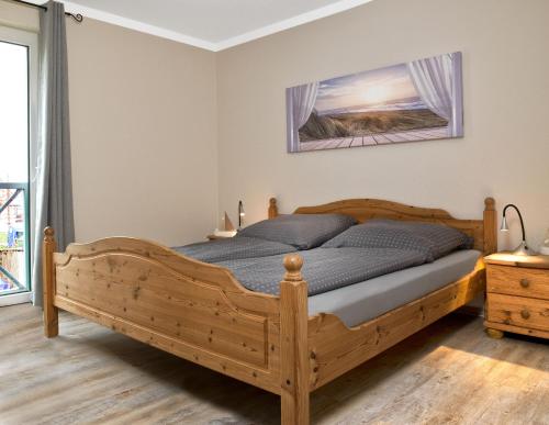 1 dormitorio con cama de madera en una habitación en Residenz am Yachthafen Schiffskieker, en Kirchdorf