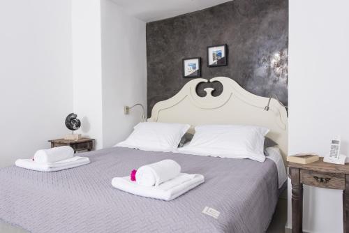 a bedroom with a bed and a lamp at Ambition Suites in Oia