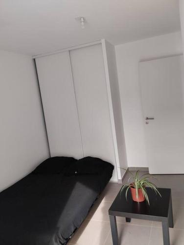 - une chambre avec un lit noir et une table dans l'établissement Appartement T3 gare st rock, à Montpellier