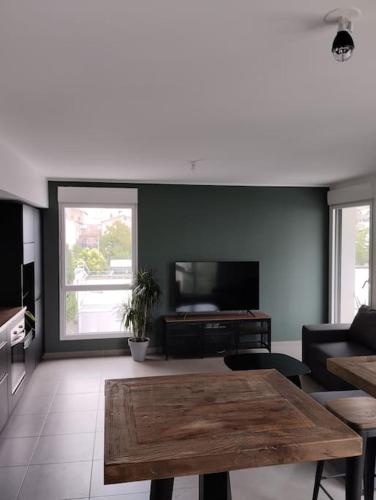 un salon avec une table et une télévision dans l'établissement Appartement T3 gare st rock, à Montpellier