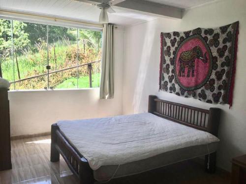 a bedroom with a bed in a room with a window at Casa especial em Itacaré in Itacaré