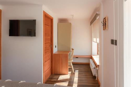 a room with a door and a desk and a chair at PURA Hotel in Coihaique
